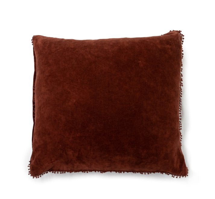 Coussin en velours à pompons